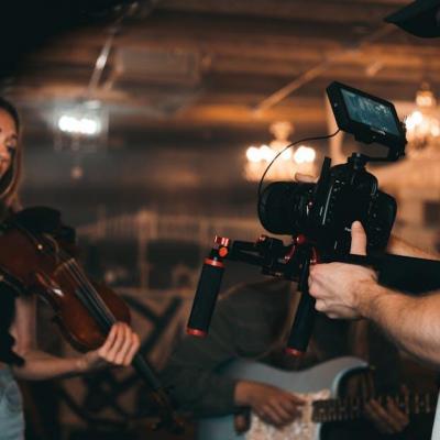 Homme prenant une video d une femme portant un violonhmdrdf